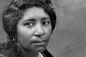 Portrait of Hall wearing a fur, earrings, a large broach, and a necklace.