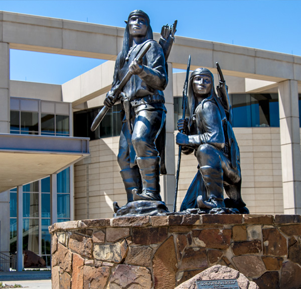 Bronze statue of two armed Apache warriors, which stands at the Oklahoma History Center entrance.