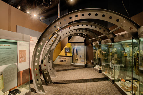 Part of the military exhibit with uniforms and artifacts in cases.