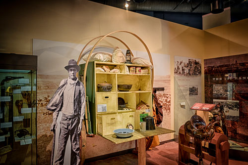 A chuckwagon exhibit with an historic life-sized photo cutout of a cowboy
