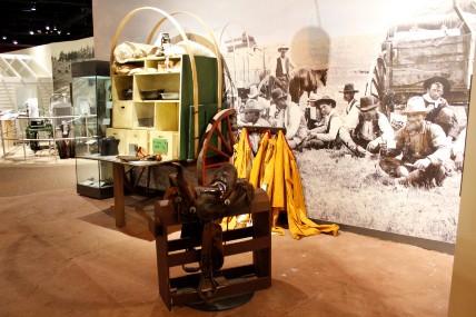 Part of a chuckwagon, with a large photograph of cowboys on the wall.