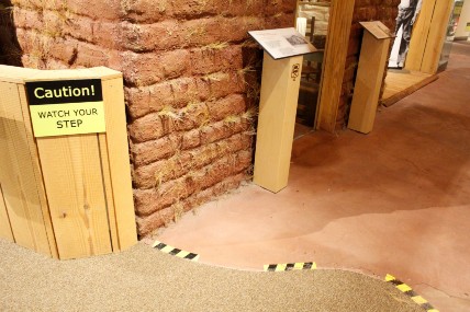 Yellow and black borders show the floor is uneven in front of the sod house exhibit
