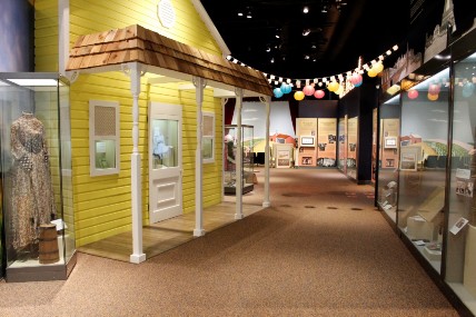 The exterior of a yellow farmhouse in the 'Oklahoma!' exhibit