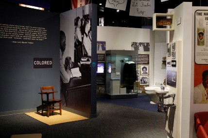 An exhibit about segregation with a single chair in an area labeled 'colored'