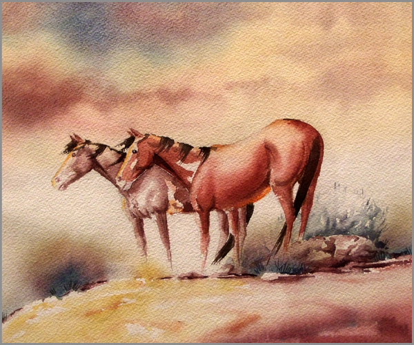 Two brown horses face the same direction in a sparse landscape. Their manes blow in the breeze.